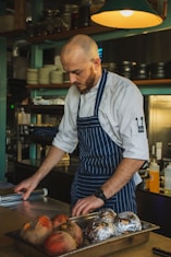 man standing in front of table holding clear plastic wrapper