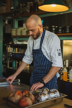 man standing in front of table holding clear plastic wrapper