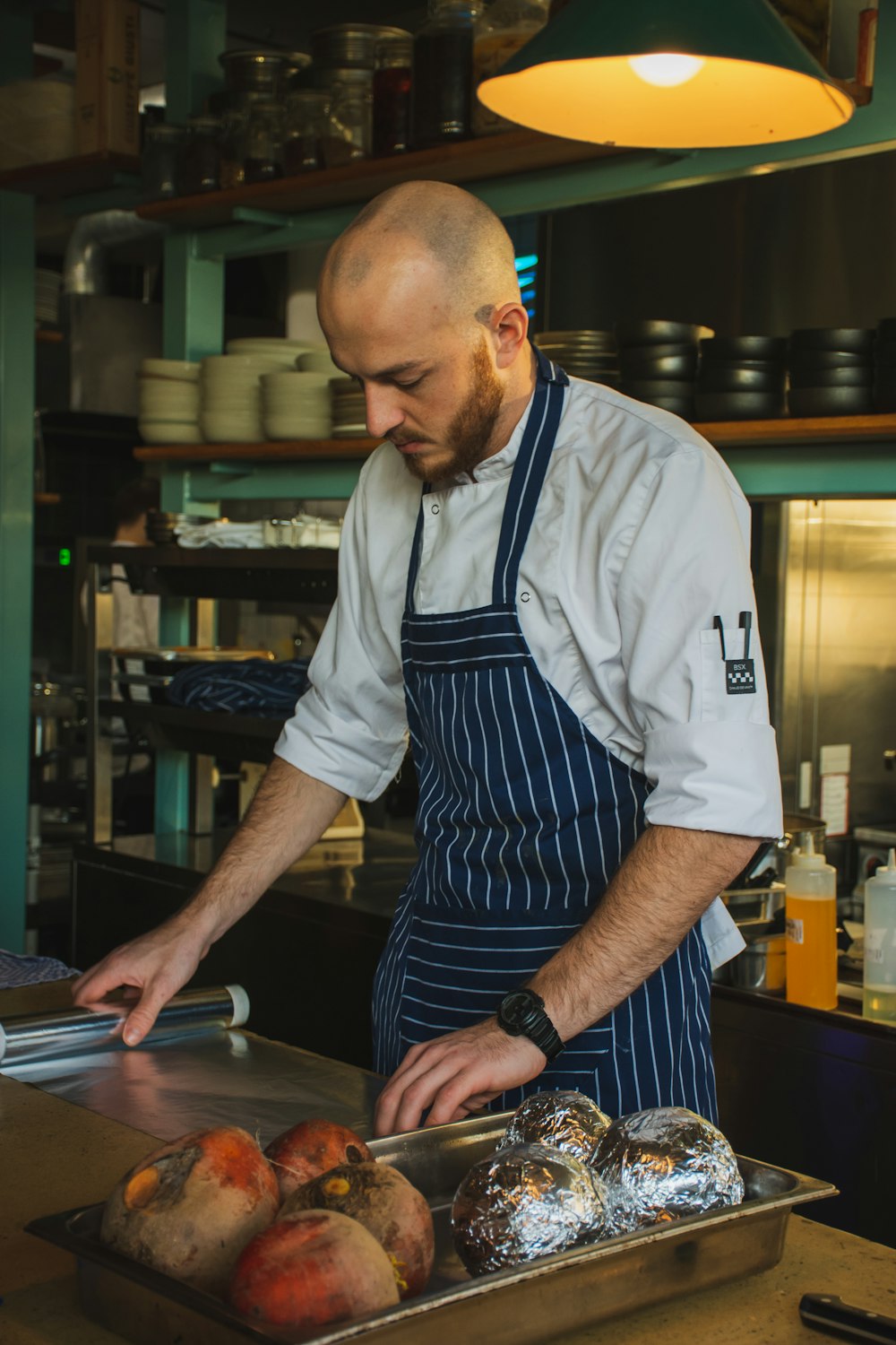 man standing in front of table holding clear plastic wrapper