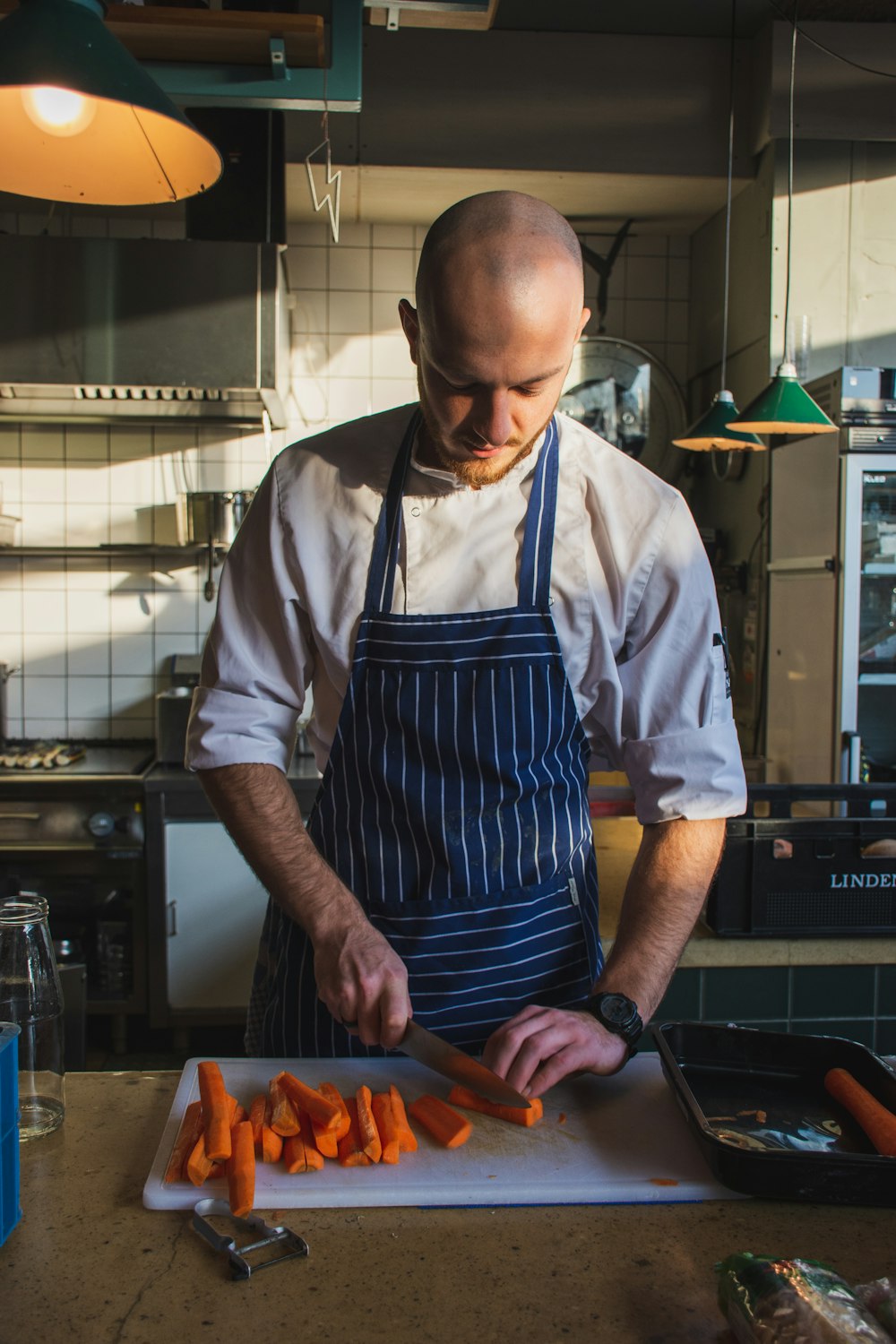 man slicing orange carrots