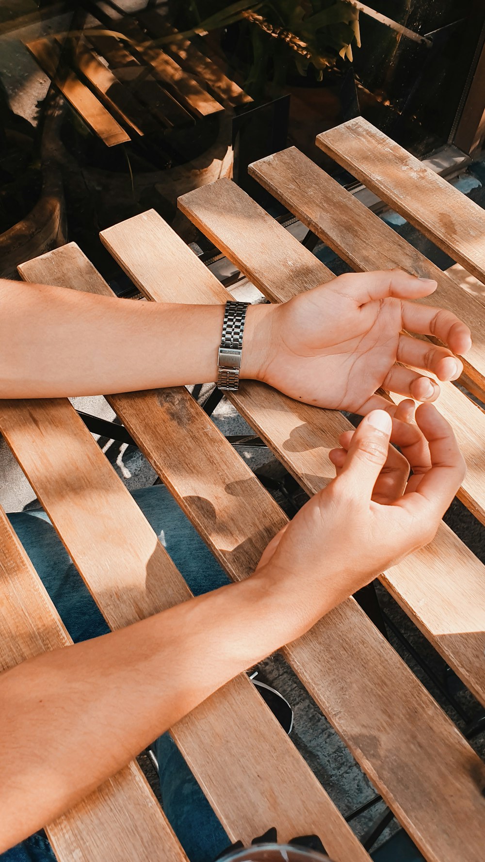 a person sitting at a table with their hands together