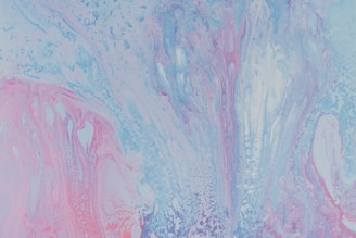 A vibrant abstract painting featuring a fluid mix of pastel colors. Swirling patterns of light blue, pink, and lavender create a dynamic and ethereal composition.