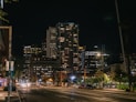 view photography of lighted high rise building near road during nighttime