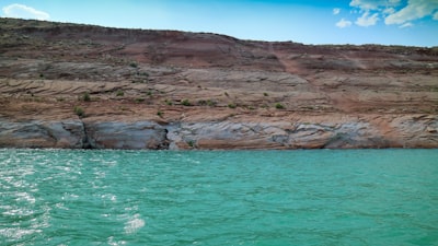 brown rock formation near sea water distinct google meet background