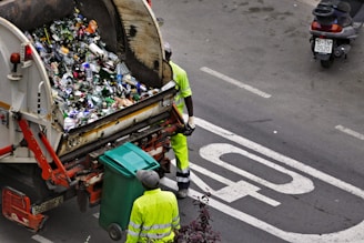 people collecting trash in garbage truck