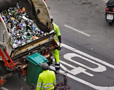 people collecting trash in garbage truck