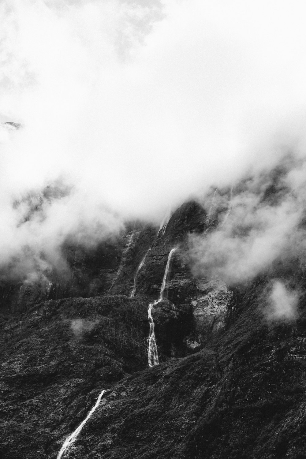 grayscale photo of hill covered with mist