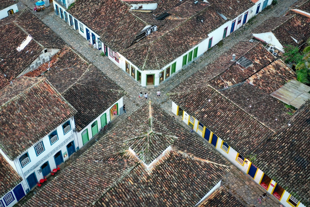 3 person standing by an open door beside buildings during daytime