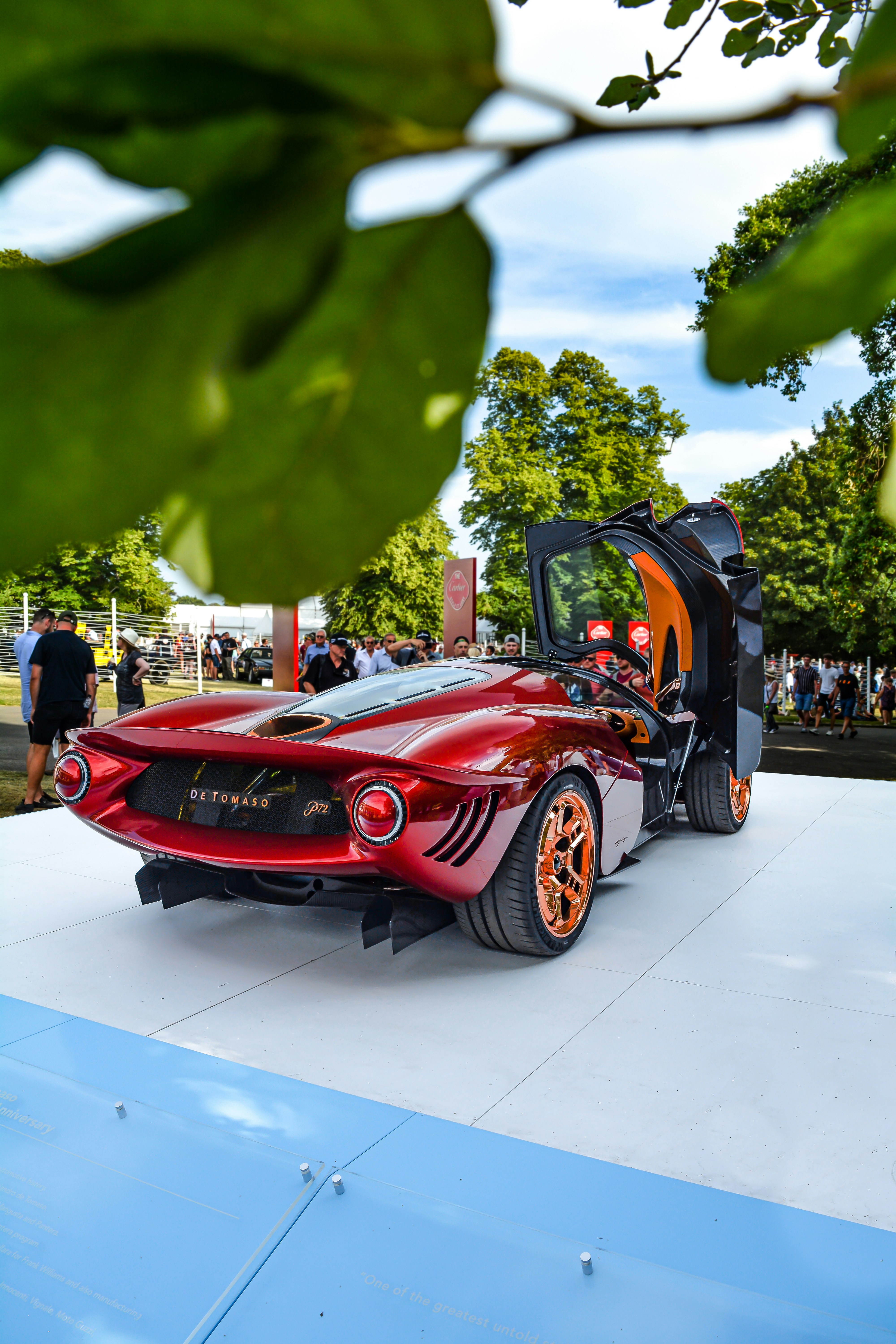 赤い高級車の横に立っている人の写真 Unsplashで見つけるイギリスの無料写真