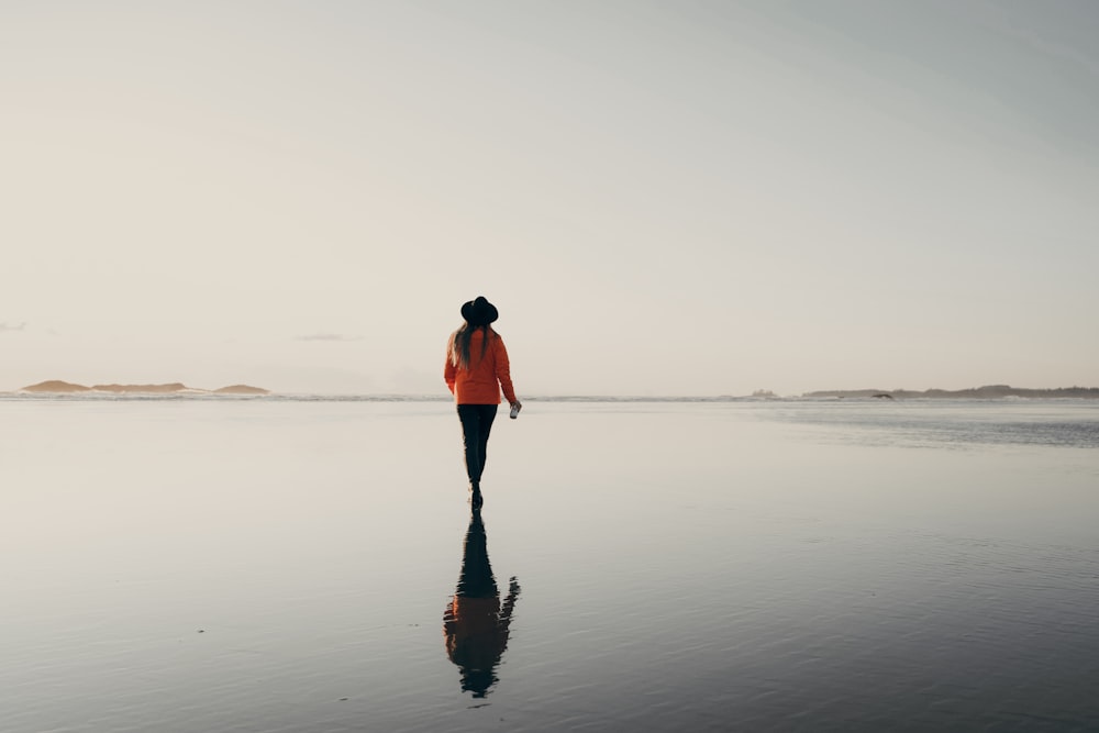 donna in top rosso che cammina sulla spiaggia