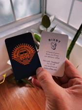 person holding two Members Only Bixby cards