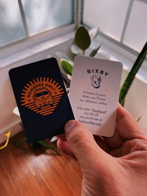 person holding two Members Only Bixby cards