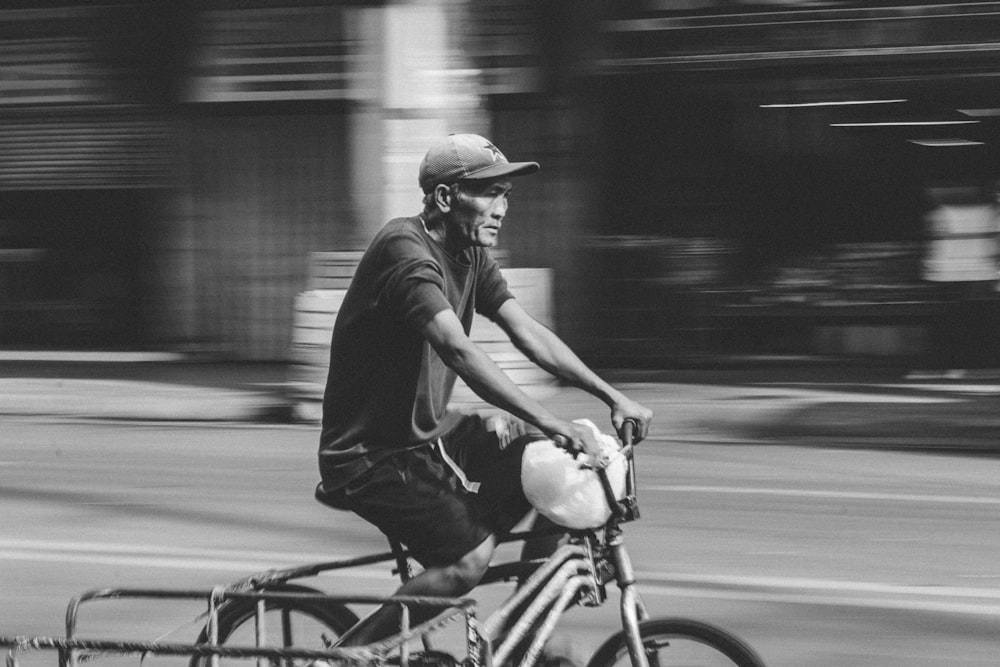 motion photo of man riding trike in monochrome photo