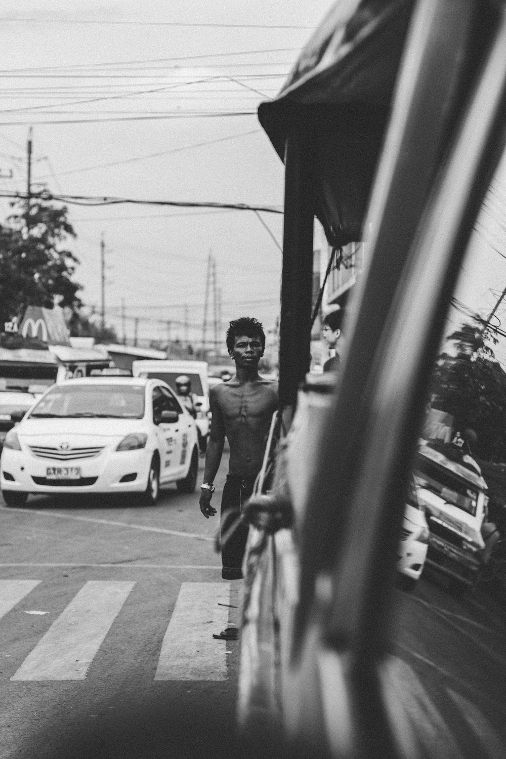 grayscale photo of topless man on pedestrian lane