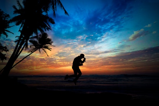 silhouette of jumping person at shore during golden hour in Pantai Karang Bolong Indonesia