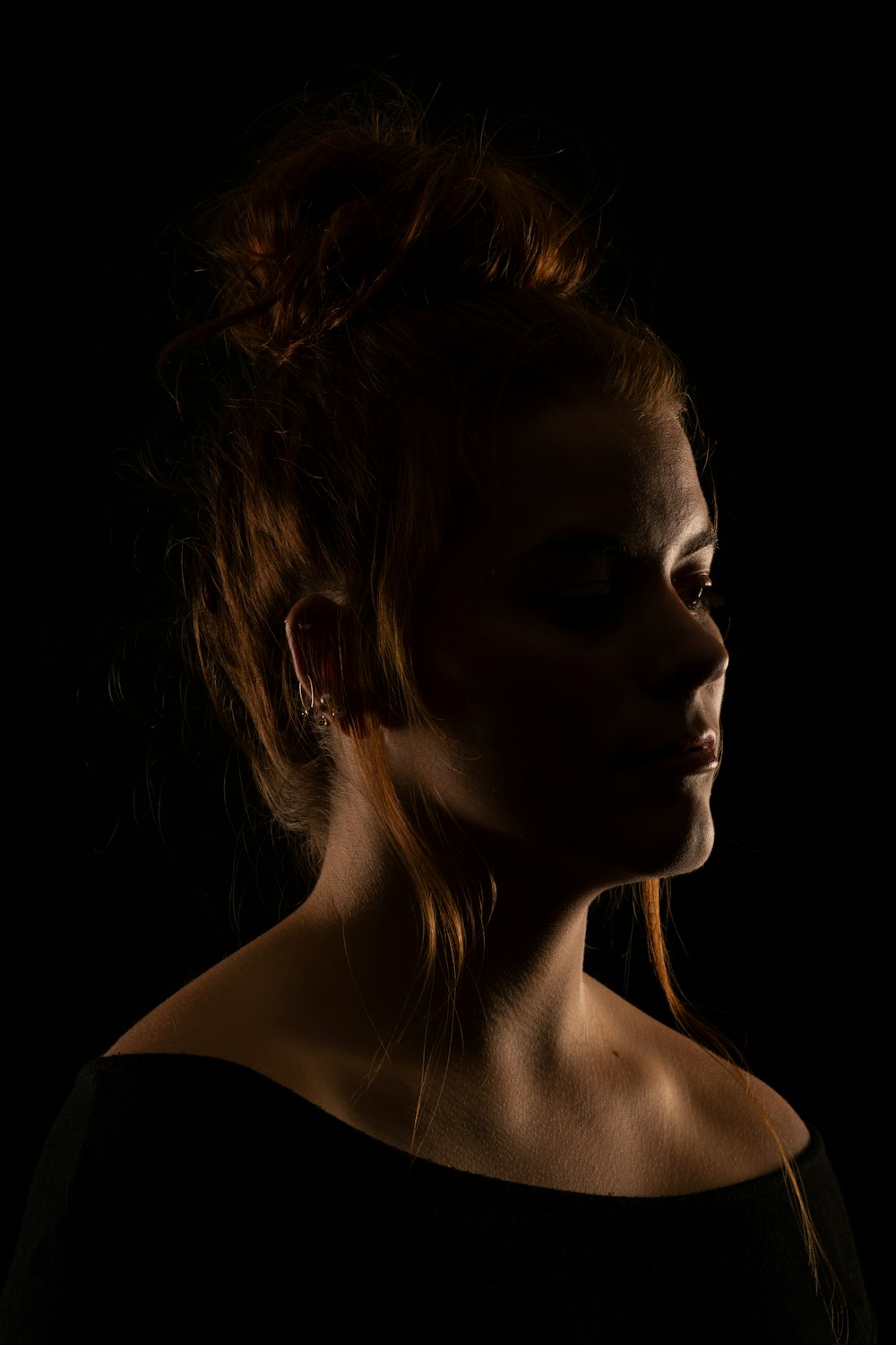 a woman with red hair and a black background