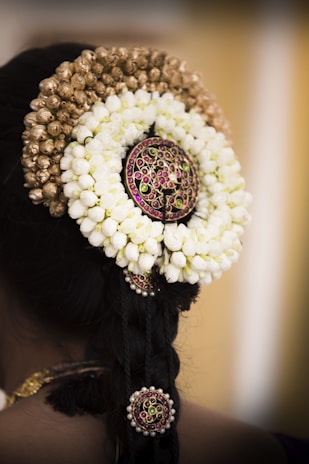Side profile of a bride with a classic updo hairstyle adorned with fresh jasmine flowers.