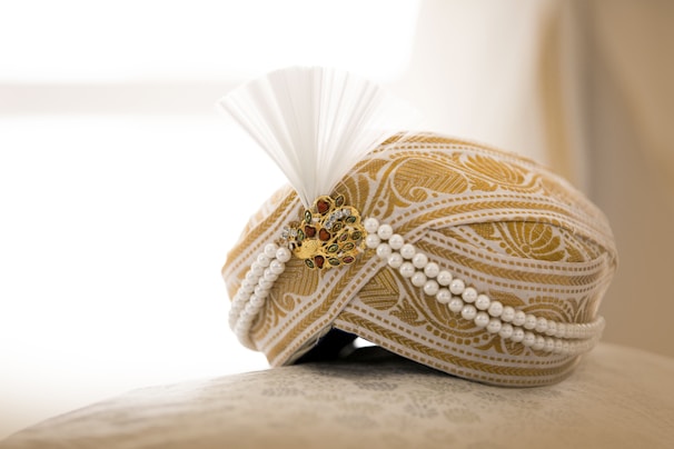 A delicate golden mukut adorned with tiny pearls and intricate designs.
