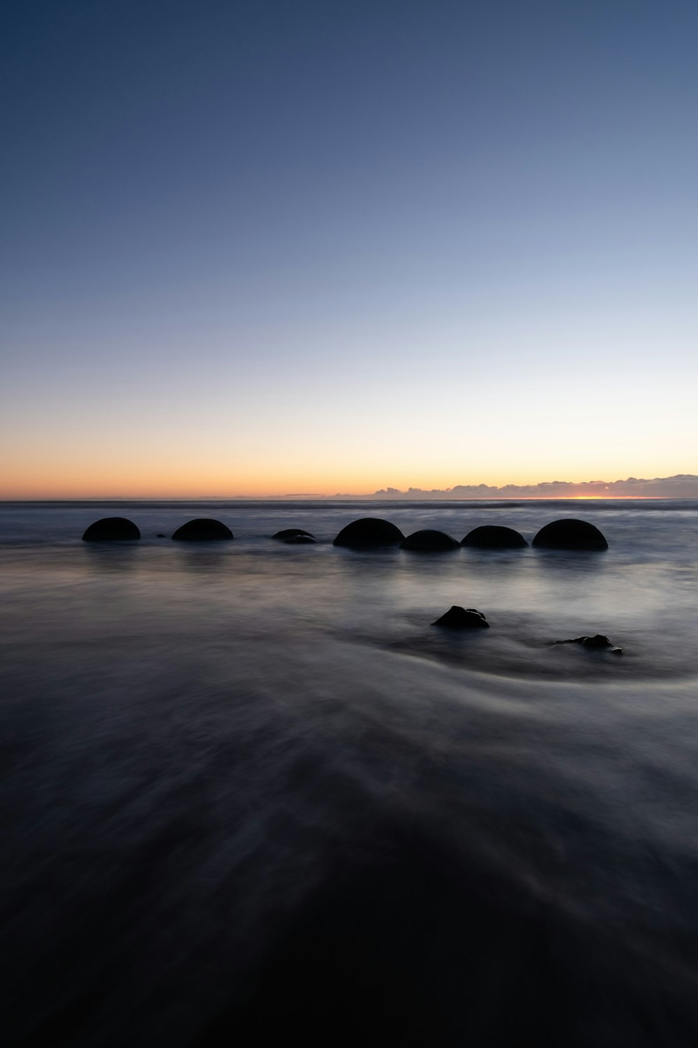 a group of rocks sitting on top of a beach