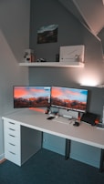 A clean, minimalistic desk setup featuring dual monitors showing software support dashboards.