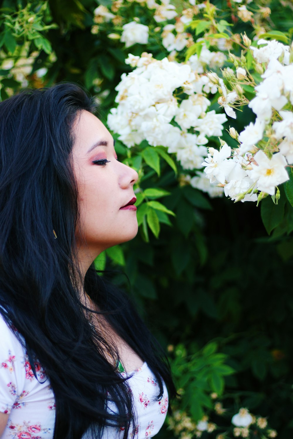 portrait of woman wearing white and red floral blouse