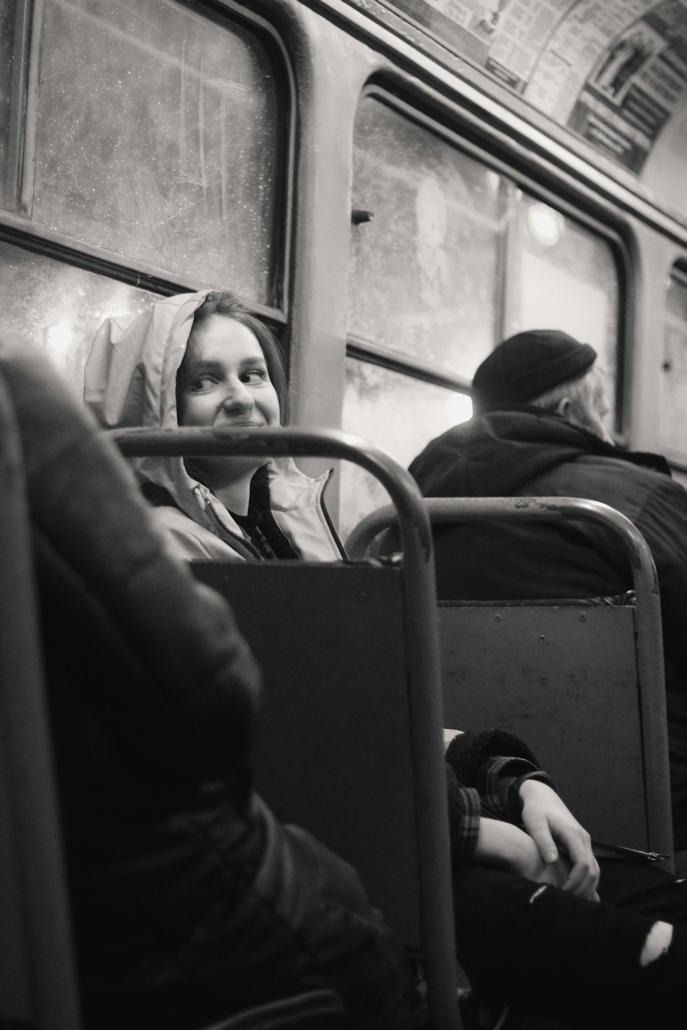 grayscale photo of woman sitting on transit bus