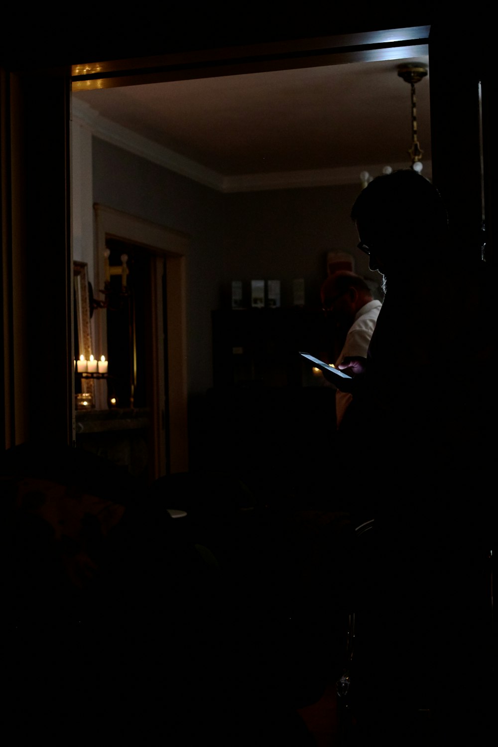 a person standing in a dark room holding a tablet
