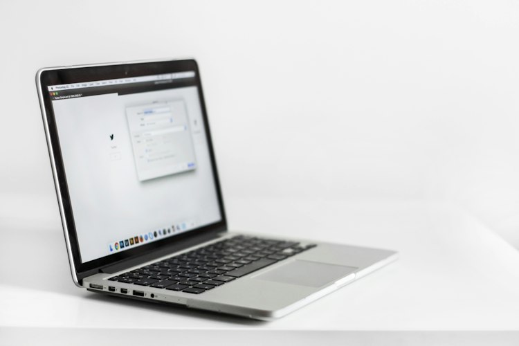 A person typing an email on a laptop at a co-working desk