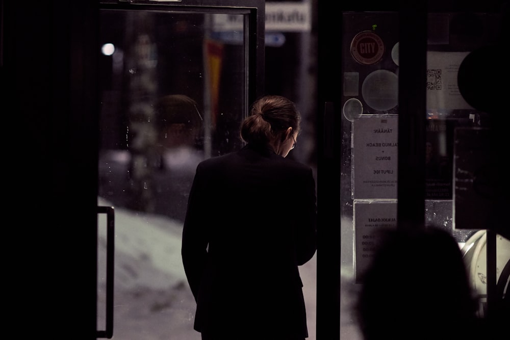 person in black top standing beside door