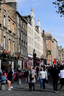Historic brick buildings lining a lively city street filled with local shops and cafes.