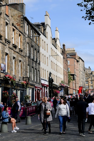 Historic brick buildings lining a lively city street filled with local shops and cafes.