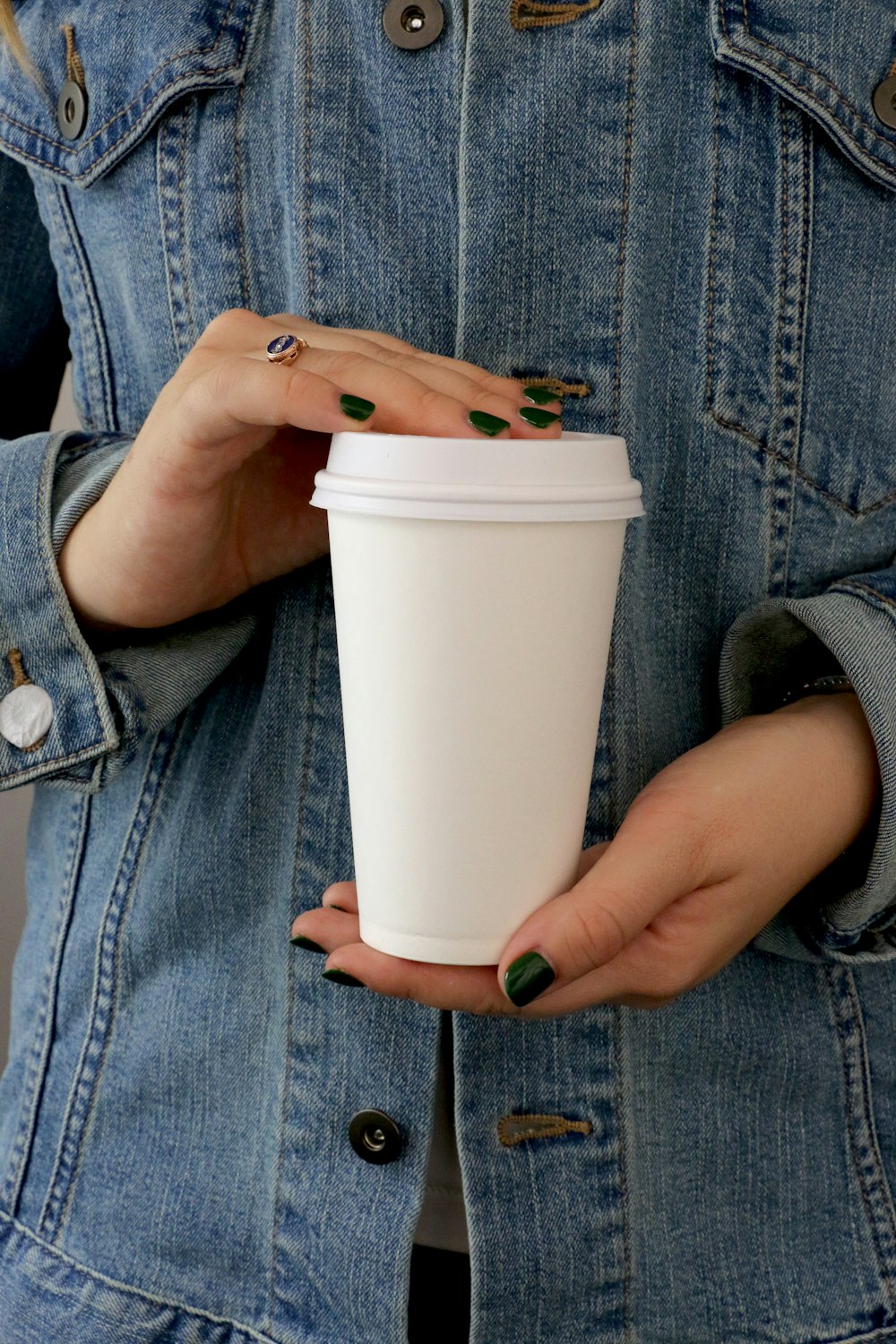 person holding white tumbler