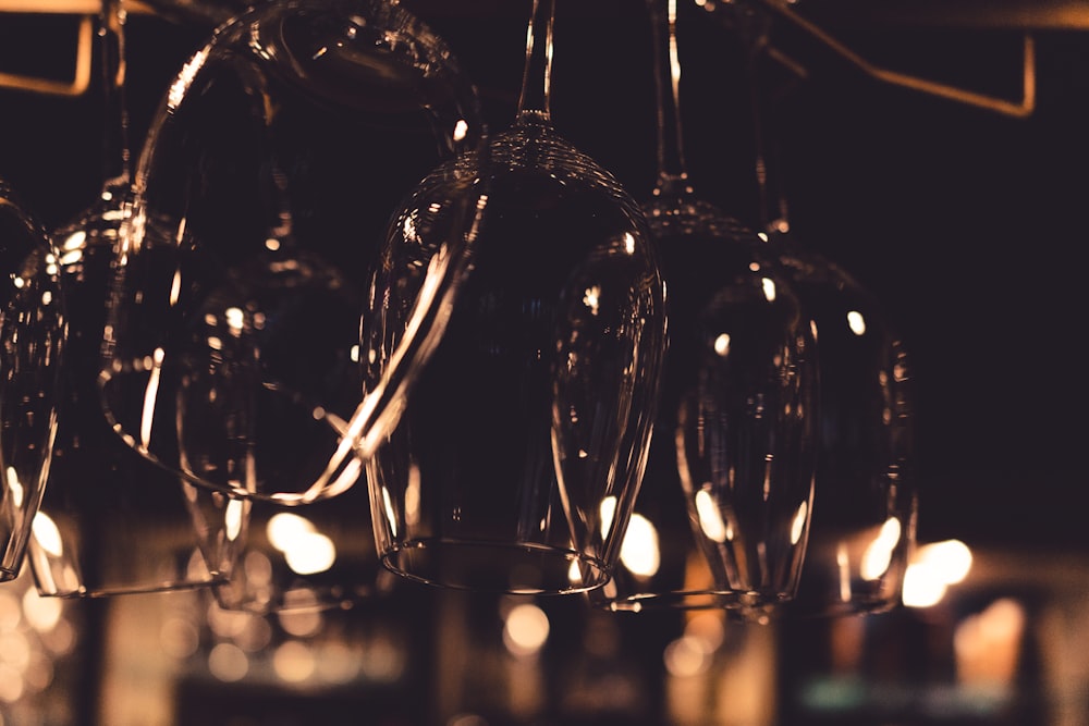 selective focus photography of glass cups on hanging rack