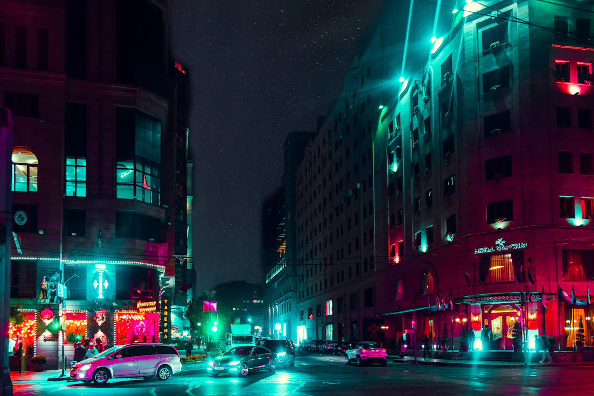 A city skyline after dark, lit towers standing over a quiet stretch of river.