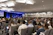 Dr. Z speaking at a conference with attentive audience in the background
