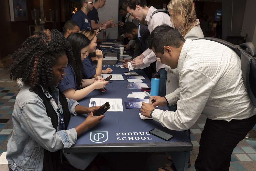 group of people sitting by table while other group of people standing by tqable