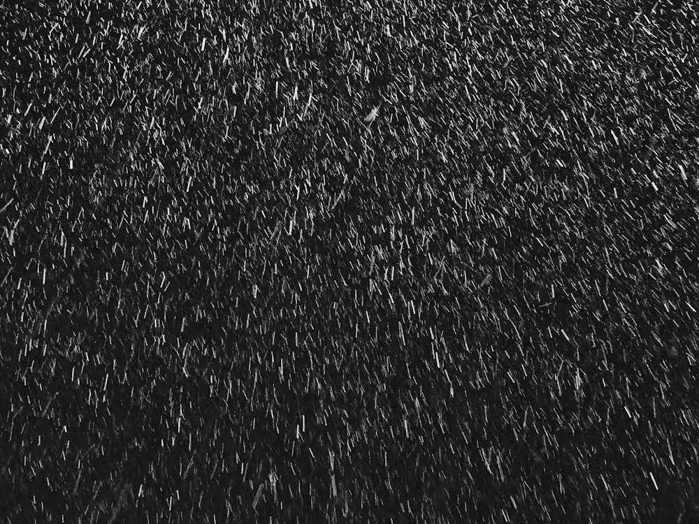 a black and white photo of snow falling