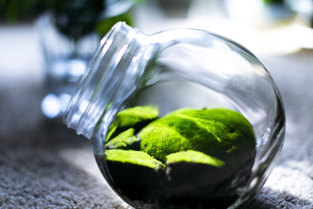 green fruit on clear glass jar