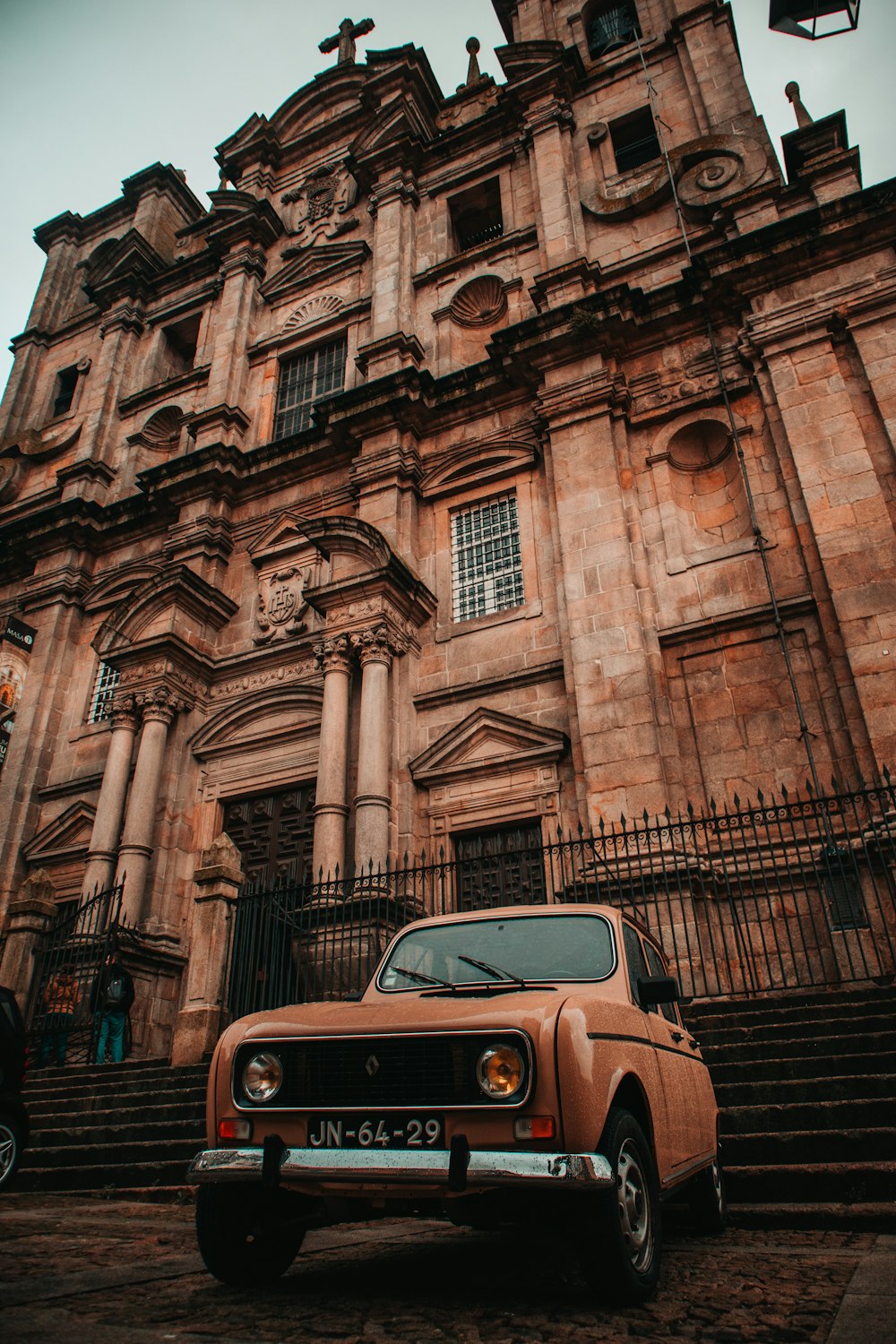 brown vehicle parked beside building