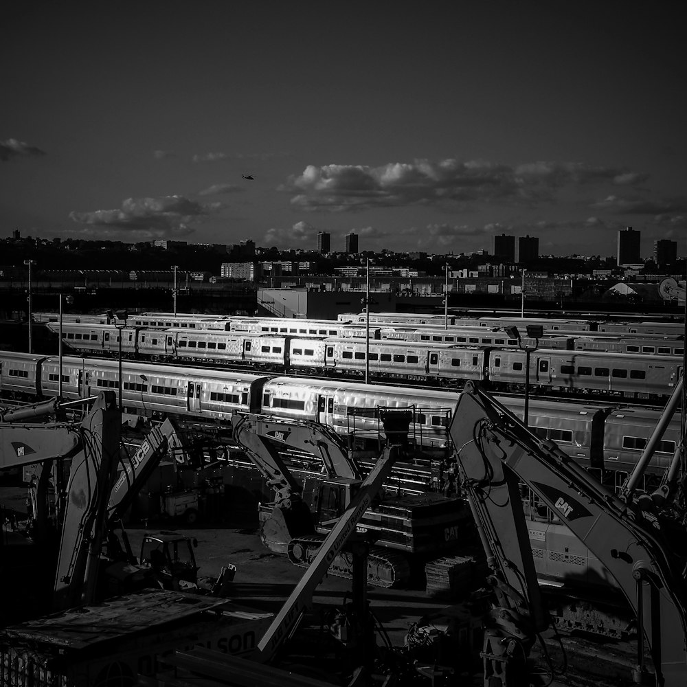 grayscale photography of city with high-rise buildings viewing train station