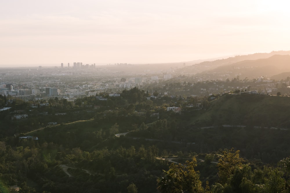 aerial photography of buildings and houses on green field viewing mountain during daytime