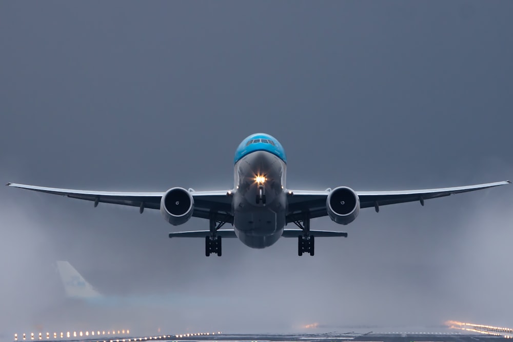 空に浮かぶ灰色と青の飛行機