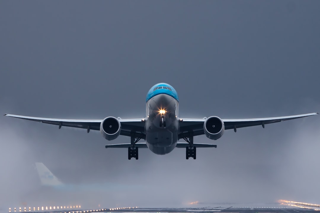 gray and blue airplane in the sky, KLM Boeing 777 leaving Kaagbaan Amsterdam Schiphol rainy weather