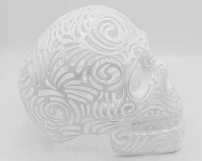 An intricately designed white skull with ornate, swirly patterns covering its surface. The patterns give it a lace-like, delicate appearance, and the material appears glossy or ceramic. The background is plain and matches the skull's color, adding to a uniform aesthetic.