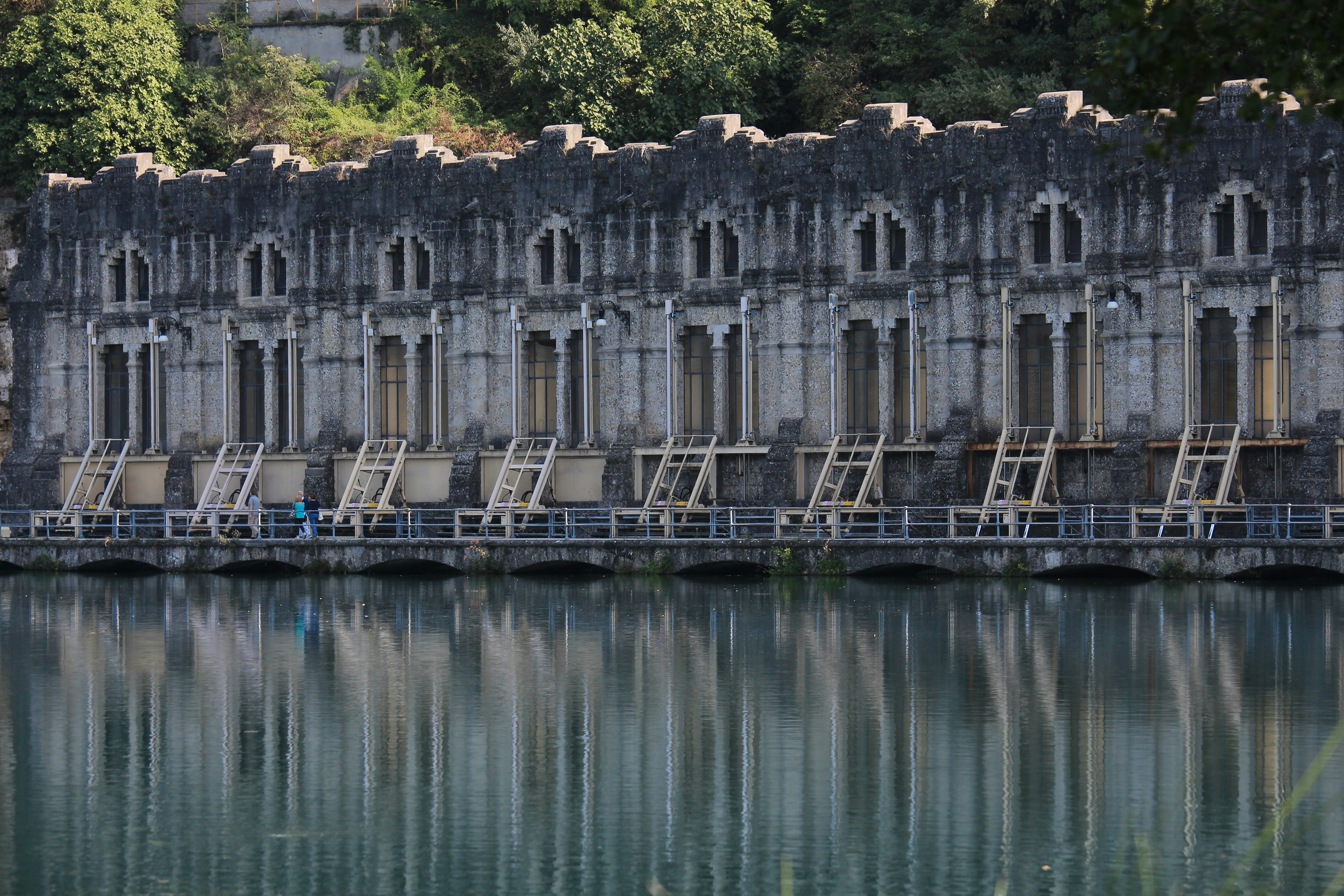 Refleksi bangunan beton abu-abu pada badan air