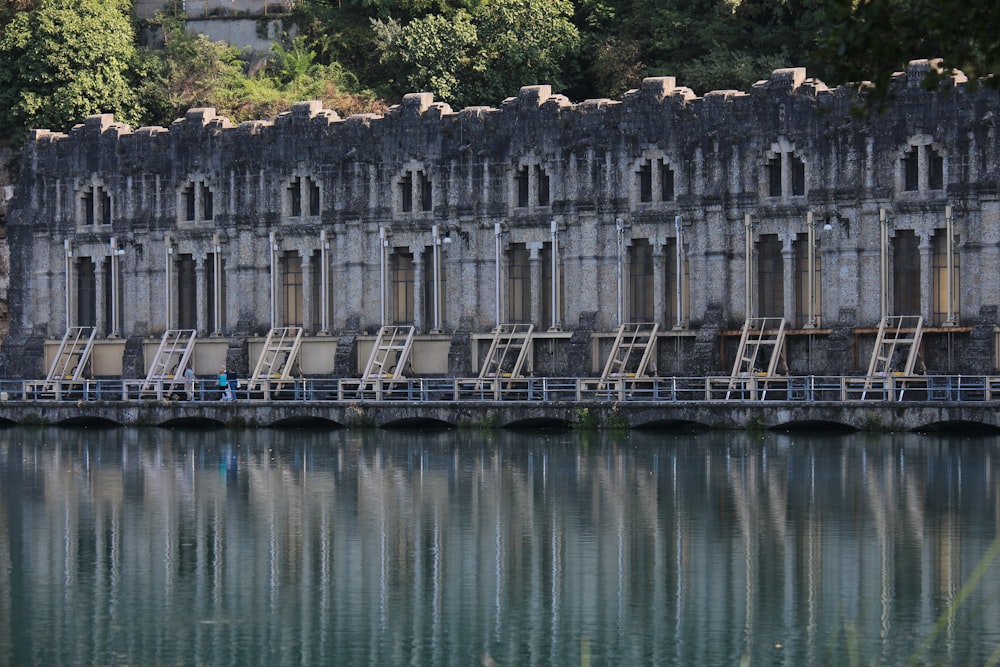 gray concrete building reflection on body of water