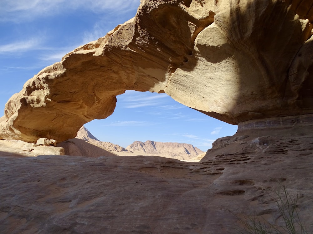 natural arch under blue and white sky during daytime