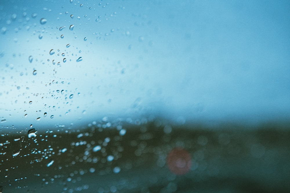 a rain covered window with a blue sky in the background