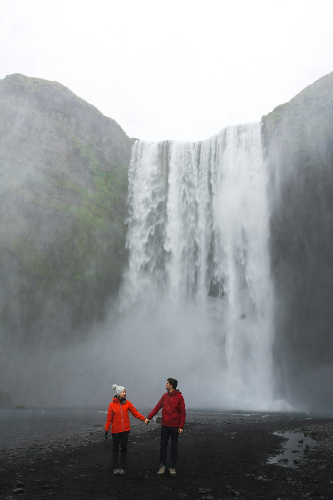 couple standing near waterfalls