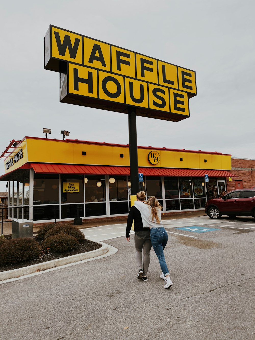 man and woman walking towards Waffle House store